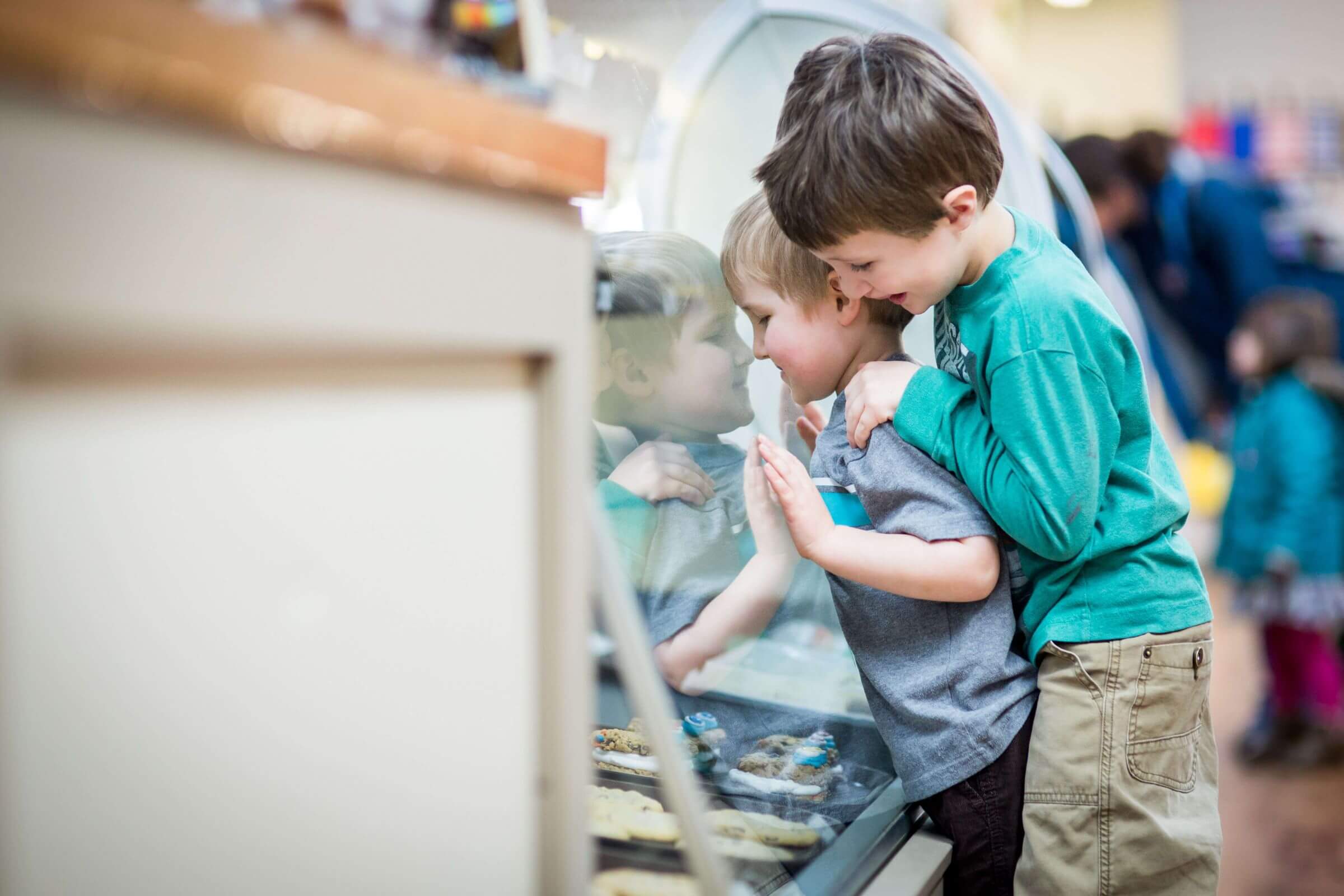 Little Boys looking into Bakery Glass